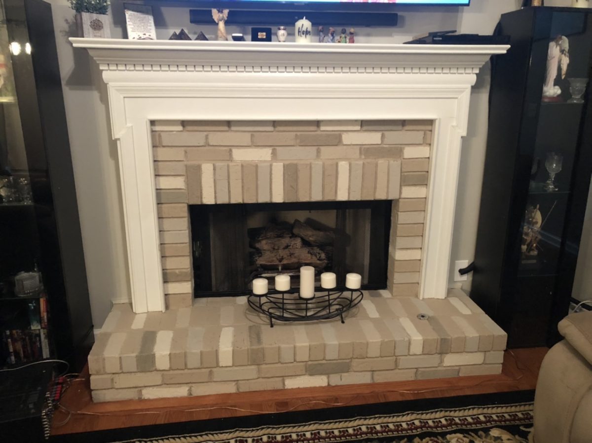 Gray painted brick fireplace with each brick shaded a slightly different gray.
