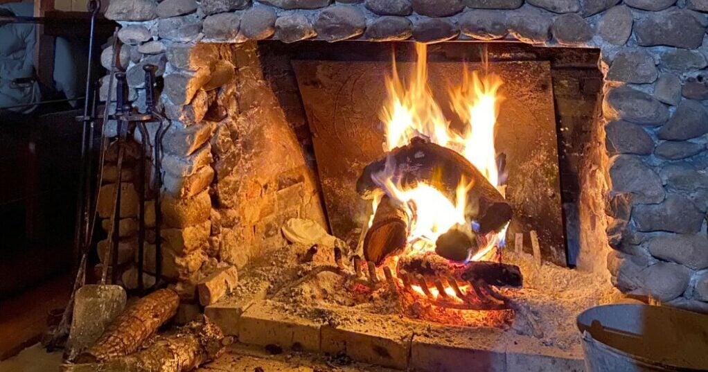 Old fashioned fireplace burning a log.