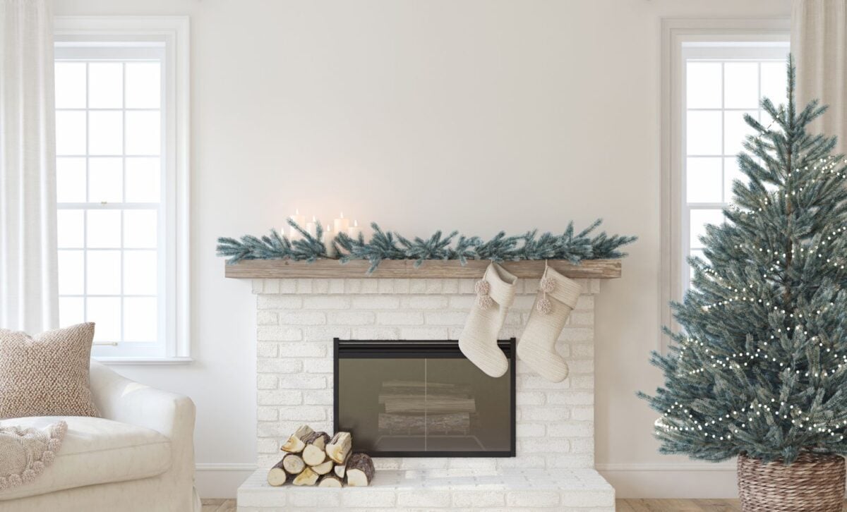 A white brick fireplace with Christmas decorations.