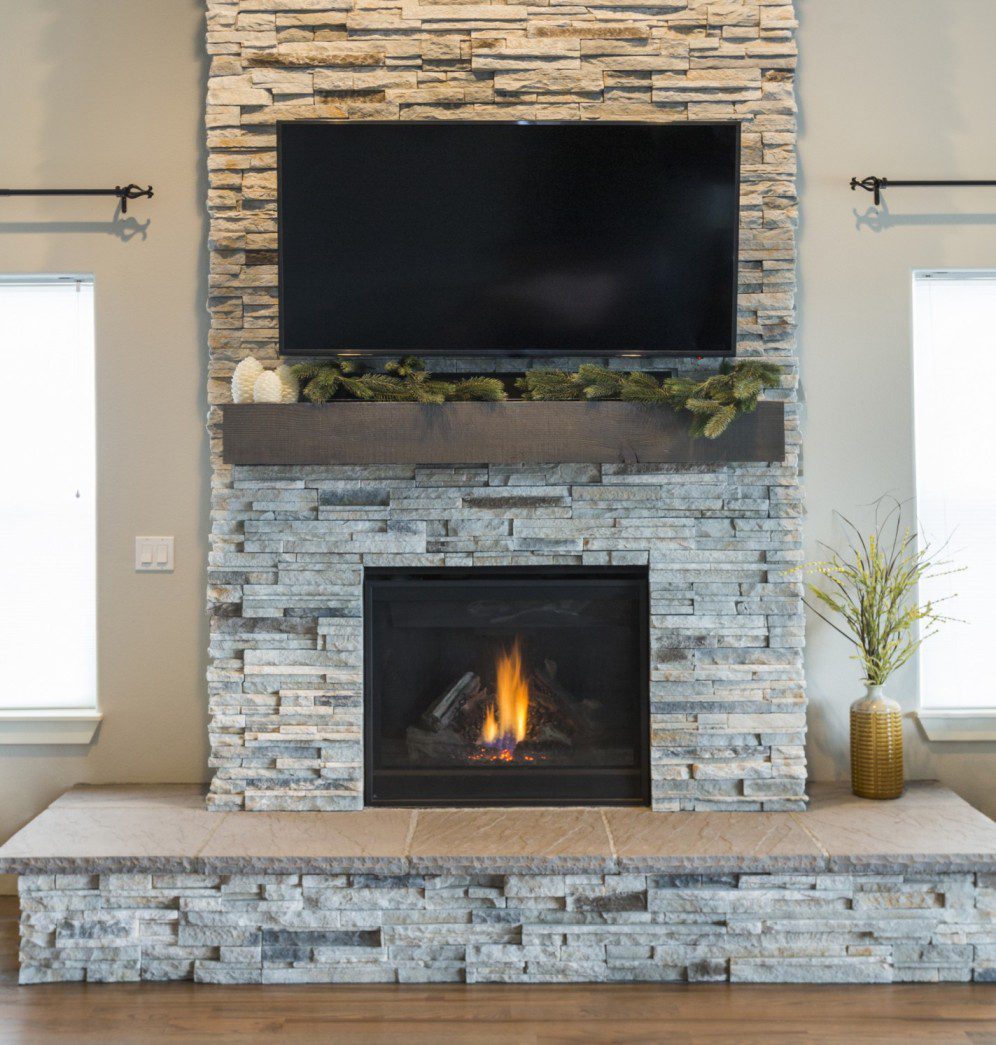 Stacked stone fireplace with a floating mantel above