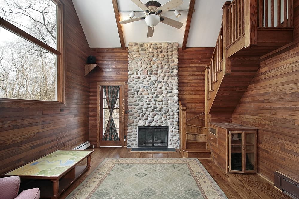 Stone ceiling height fireplace in wood cabin